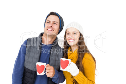 Smiling couple holding mug and looking away