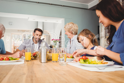 Family with grandparents sitting at dining table