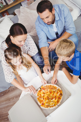 High angle view of family taking pizza slices