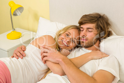 Cute couple cuddling in their bed