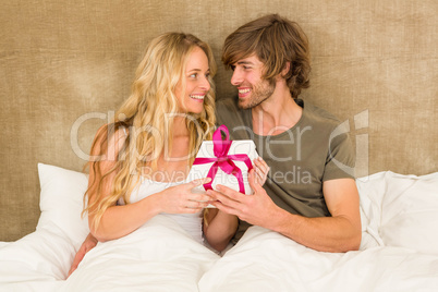 Cute couple holding a gift box