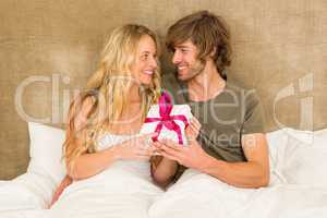 Cute couple holding a gift box