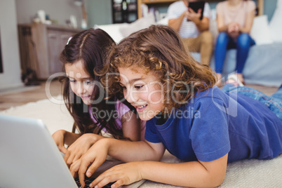 Close-up of siblings using laptop at home