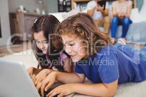 Close-up of siblings using laptop at home