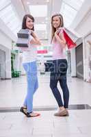 Portrait of two beautiful women shopping in mall