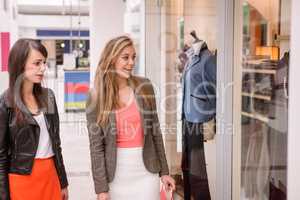 Two beautiful women window shopping in mall