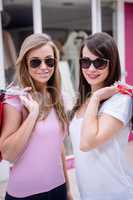 Portrait of beautiful women in sunglasses holding shopping bags