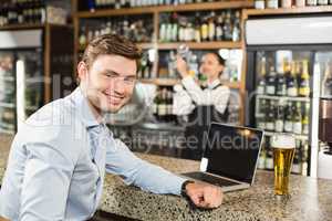 Man smiling at camera in a bar