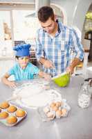 Boy helping father in preparing food