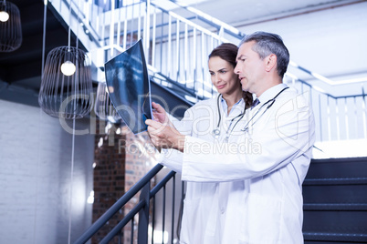 Doctors examining a x report on staircase