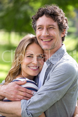 Smiling couple embracing in park