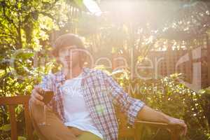 Man sitting on a bench with a glass of red wine