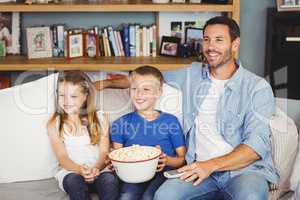 Cheerful family with popcorns while watching television