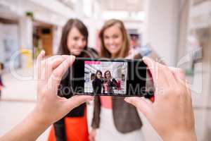 Two woman clicking a photo in phone