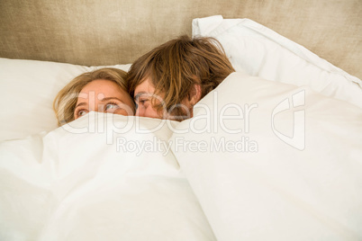 Cute couple cuddling under the blanket