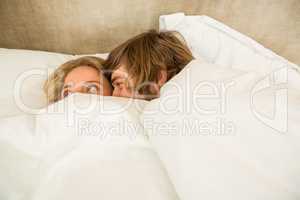 Cute couple cuddling under the blanket