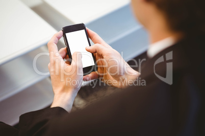 Businessman text messaging on smartphone