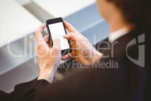 Businessman text messaging on smartphone