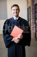 Lawyer standing near library with law book