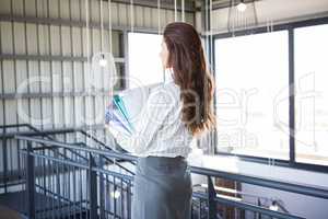 Busy businesswoman carrying folders with files documents