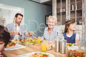 Smiling granny while sitting at dining table