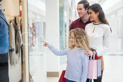 Happy family window shopping in mall