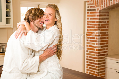 Cute couple cuddling with girlfriend sitting on the counter