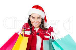 Beautiful brunette with santa hat holding shopping bags