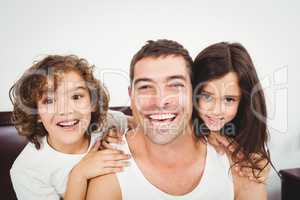 Cheerful father with daughter and son at home