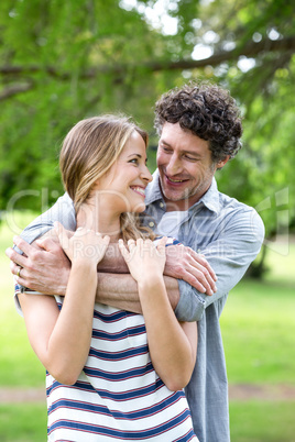 Smiling couple embracing in park