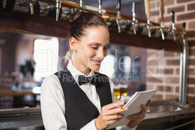 Barmaid taking orders on notepad