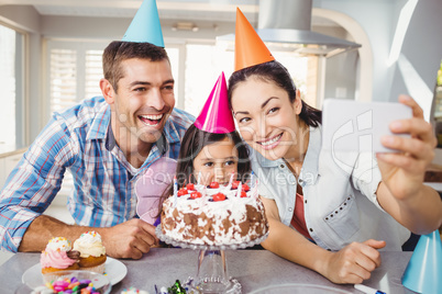 Happy family taking selfie during birthday celebration