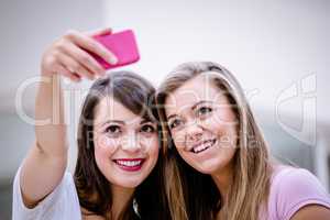 Two beautiful women taking a selfie on mobile phone