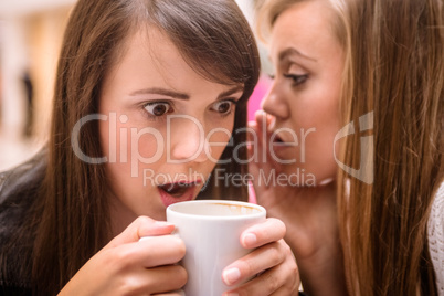 Woman whispering in her friends ears