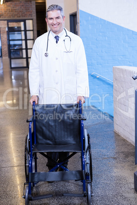 Male doctor standing with wheel chair