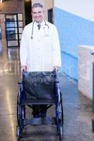 Male doctor standing with wheel chair