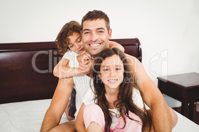 Father with daughter and son on bed