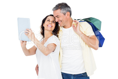 Couple with shopping bags looking at PC tablet