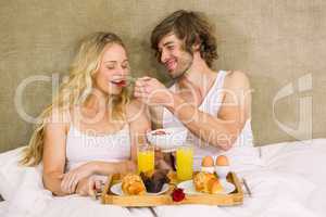 Cute couple having breakfast in bed