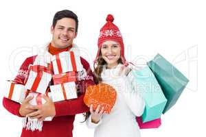 Happy couple with winter clothes holding gift boxes and shopping