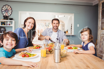 Portrait of happy family with food on dining table