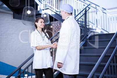 Doctors shaking hands on staircase