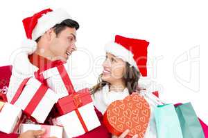 Happy couple with santa hats holding gift boxes and shopping bag