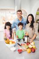 Portrait of smiling family preparing fruit juice