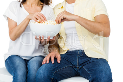 Smiling couple eating popcorn