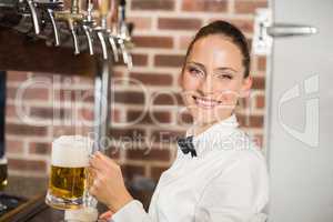 Barmaid holding beers while smiling at camera