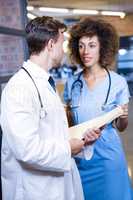 Doctor discussing medical report with female nurse
