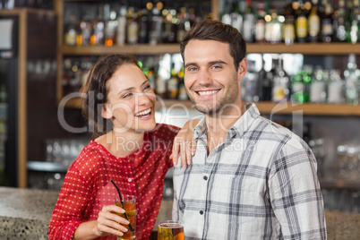 Couple smiling at camera and holding beers