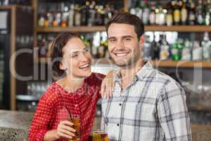 Couple smiling at camera and holding beers