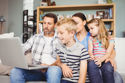 Family looking in laptop at home